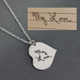Custom silver Handwriting heart necklace, personalized with the words, "My Love", and hung from the side. Shown on gray paper with the original handwritten note. With an image like this, we clean up the blur and the perspective distortion, and remove the lines.