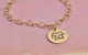 Custom memorial gold charm bracelet, engraved with note in father's handwriting & his signature, with gold puffed heart, shown on white with original handwriting used to personalize the bracelet