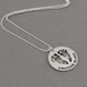 Sterling silver custom footprint necklace with your child's footprints, hand stamped with names and date, shown from the side
