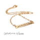 Gold bar necklace with kids' handwritten signatures in a note to Mom. Shown with the original handwriting used to personalize it