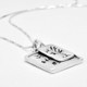 Side view of handmade silver raised edge square pendant handwriting necklace, custom engraved with kids' handwritten signatures, and with silver family tree charm.