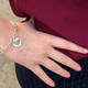 custom fingerprint charm bracelet in sterling silver, shown on model close up