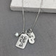 Custom fine silver Family Tree necklace, personalized with hand stamped kids' initials, hung with pearl charm, shown on gray