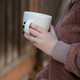 Model wearing custom Stackable Handwriting Ring, holding a cup of coffee