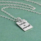 Custom Believe In Yourself Necklace for graduation, hand stamped in sterling silver, with silver star and sterling chain, shown from the side on green background
