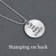 Back of custom silver etched butterfly circle necklace, personalized with couple's names & wedding date