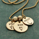 Hand stamped custom Gold Name Discs necklace personalized with kids names and symbols, shown close from the side