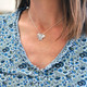 Model wearing fine silver Mini Squares personalized necklace, each square hand stamped with a name and with an embedded birthstone