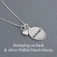 Stamped birthday date on back of custom sterling silver oval charm necklace, in Block Upper font, shown with a silver Puffed Heart Charm