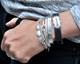 Stacked personalized bracelets, including stamped ID bracelet on a model