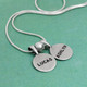 Personalized Sterling Circles of Affection, custom hand stamped silver charms with kids names, with a silver spacer bead, shown from the side