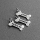 Sterling silver dog bone charm with hand stamped names to add to a personalized necklace, shown from the side