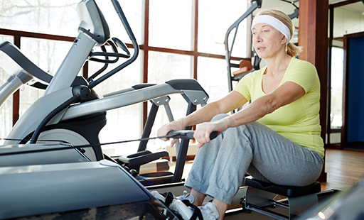 People in a gym with a machine that says scifit on it - image