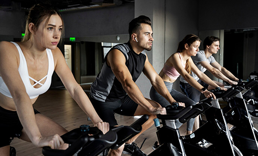 A group of people are riding exercise bikes in a gym - image
