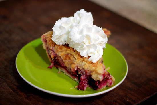 Slice of boysenberry pie with whipped cream
