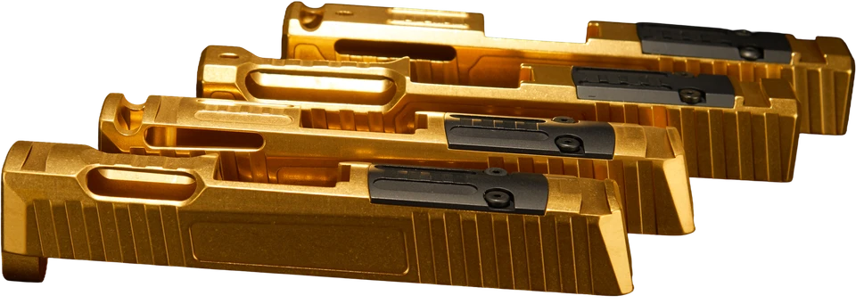 Four gold custom pistol slides