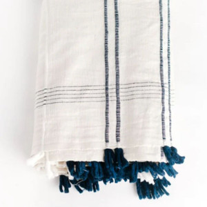 Locally sourced cotton tablecloth with handwoven details and playful blue and white tassels. Effortlessly elegant for indoor or outdoor dining. Locally sourced cotton tablecloth with handwoven details and playful blue and white tassels. Effortlessly elegant for indoor or outdoor dining.
