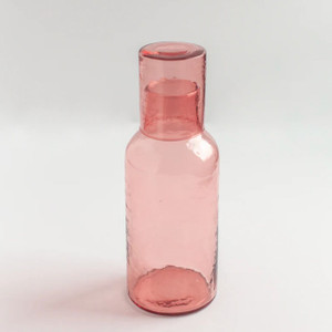 Blush colored glass carafe pitcher for entertaining. Elegant and functional, this exquisite carafe is a masterpiece of glassblowing artistry. Blush colored glass carafe pitcher for entertaining. Elegant and functional, this exquisite carafe is a masterpiece of glassblowing artistry.