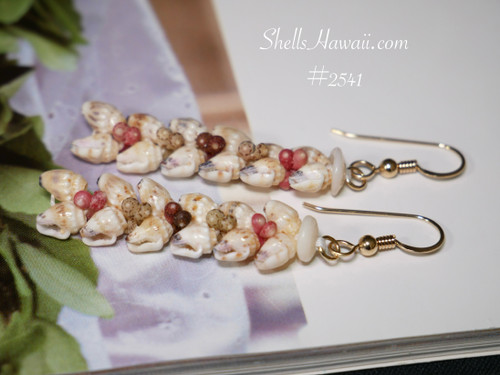 1⅝″ Heliconia Flower style Niʻihau earrings with off-white and soft yellow Momi shells, accented by pink flower, green, black, and brown Kahelelani shells. Evoking a lush tropical garden in bloom.