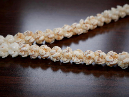 Option 1 (focus: Ni‘ihau shell lei):
21″ Ni‘ihau shell lei in Crown Flower style featuring blue ʻUliʻuli, yellow Lenalena, and pure white Keʻokeʻo Momi shells, handcrafted and radiant
