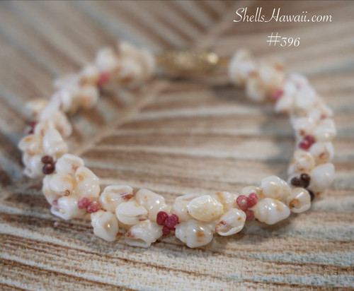 Detailed Niihau shell bracelet showing kahelelani shells in soft pink green red and brown with off white momi shells with red waha