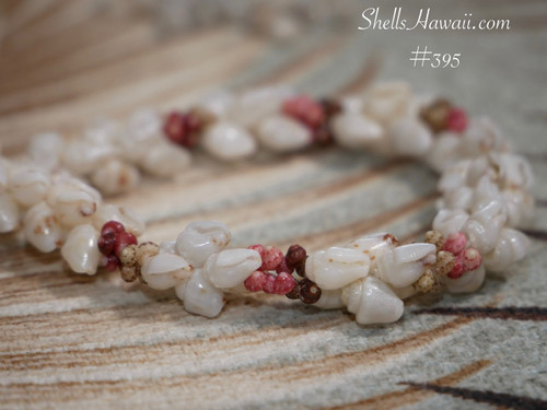 nibl_395
Hawaiian kipona style shell bracelet close up showing momi shells and kahelelani shells in red burgundy pink flower green and brown tones #395