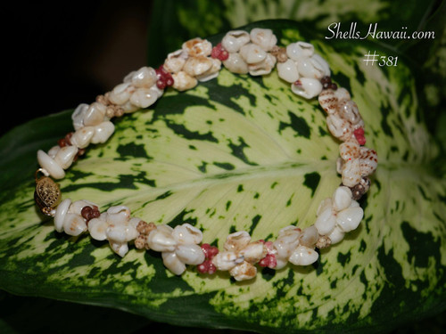 nibl_381
Niihau Momi and Kahelelani shell bracelet on green leaf background natural Hawaiian seashell jewelry off white shells with light blue undertone yellow tones and mixed color accents