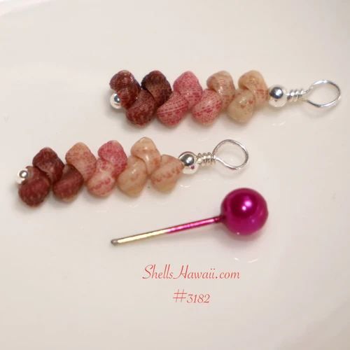 This photo shows the Kahelelani shell earrings laid flat, highlighting the soft ombre blend of burgundy, pink, and off white shells. The colors transition gently in a minimalist drop design, showing the natural beauty of Hawaiian shell jewelry made with shells from Kauaʻi.