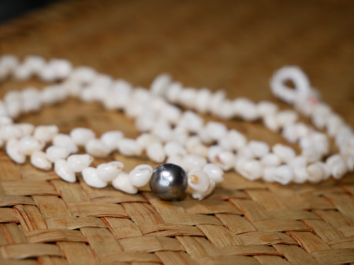 ninl_2012
Traditional Hawaiian shell necklace featuring off white Momi shells from Niʻihau with a peacock Tahitian pearl in baroque shape. Handmade Hawaiian shell necklace with flowing shellwork and natural island style, shown laid on woven lauhala background.