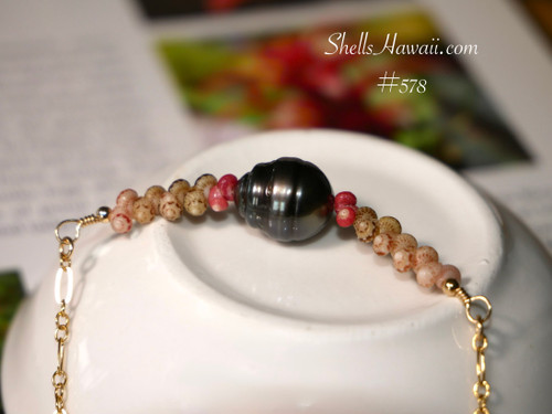 PD_578
A minimalist floating pattern of genuine Kahelelani shells surrounding a 9.93 mm Tahitian pearl centerpiece, resting in a white dish. This authentic Niʻihau shell jewelry piece is a luxury island gift and handmade Tahitian pearl pendant necklace.