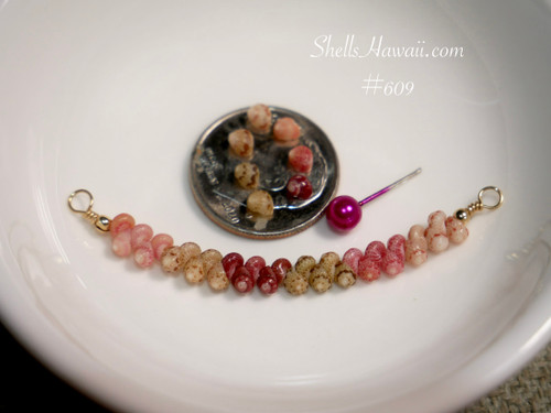 pd_609
Authentic Hawaiian shell necklace from Niʻihau displayed in a white ceramic dish featuring a soft ombré arrangement of genuine Kahelelani shells in a minimalist curved floating shell necklace design.
