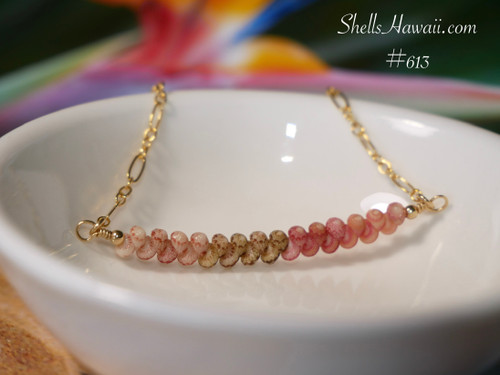 pd_613
Close-up view of the minimalist curved floating shell necklace displayed in a white ceramic bowl showcasing the overall pendant design, flowing ombré color arrangement, and delicate handcrafted pattern of genuine Kahelelani shells from Niʻihau in Keʻokeʻo, green, pink flower, and soft pink tones.