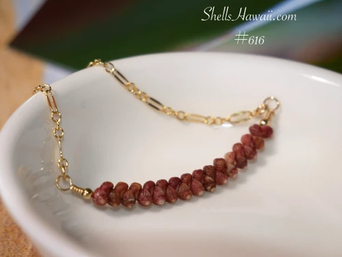 Close-up overall view of the minimalist shell pendant resting inside a white ceramic bowl highlighting the smooth shell pattern, handcrafted workmanship, and natural burgundy Kahelelani shell tones with soft wine and reddish variations.