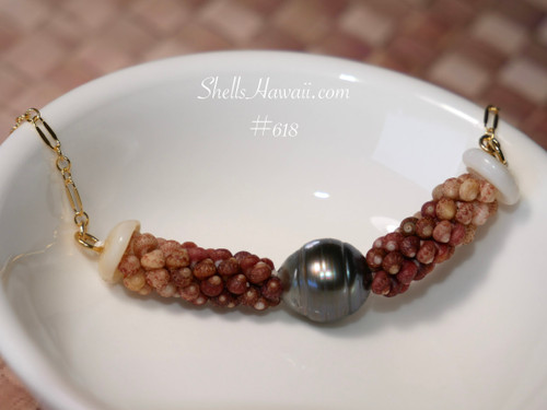 Close-up overall view of the triple strand poepoe shell pendant resting inside a white ceramic bowl highlighting the rich ombré shell pattern, silver tone Tahitian pearl, organic shell texture, and handcrafted Hawaiian shell artistry.