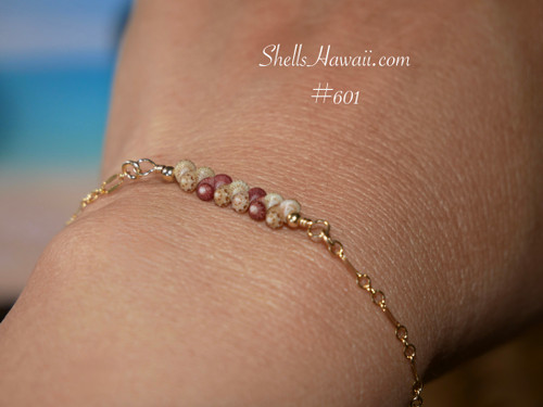 Very close-up wrist view highlighting the tiny handcrafted Kahelelani shells, delicate gold filled chain details, and soft everyday wear Hawaiian jewelry style created with shells from Niʻihau and Kauaʻi.