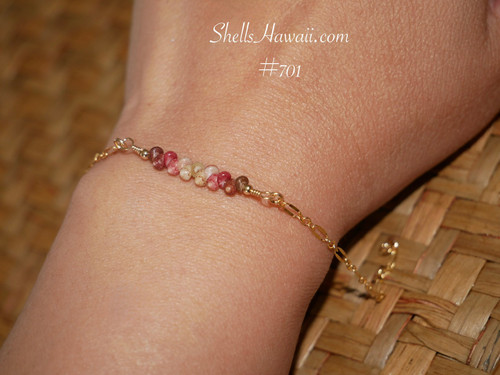 Dainty Kahelelani shell bracelet worn on wrist featuring genuine Niʻihau shells with soft natural ocean colors and delicate 14k gold filled chain. Elegant everyday Hawaiian shell jewelry with refined coastal style and understated island luxury.