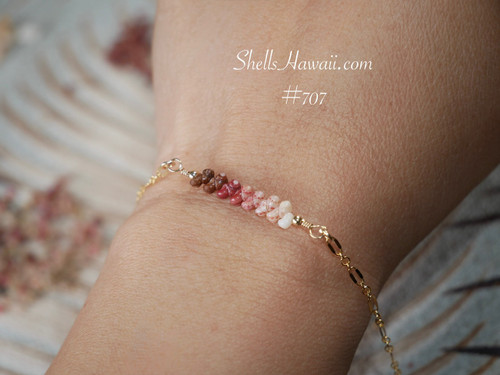 bl_707
Ombré Kahelelani Hawaiian shell bracelet worn on wrist featuring genuine Niʻihau shells in a soft gradient of brown, red burgundy, pink, and keʻokeʻo off white tones. Elegant everyday Hawaiian shell jewelry with tropical coastal charm and understated luxury style.