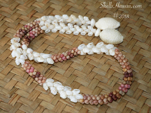 ninl_2018
Full view of a handmade Kipona Style Hawaiian shell necklace handcrafted with Kahelelani, Momi, and Granulated Cowrie shells displayed on a woven lauhala mat.