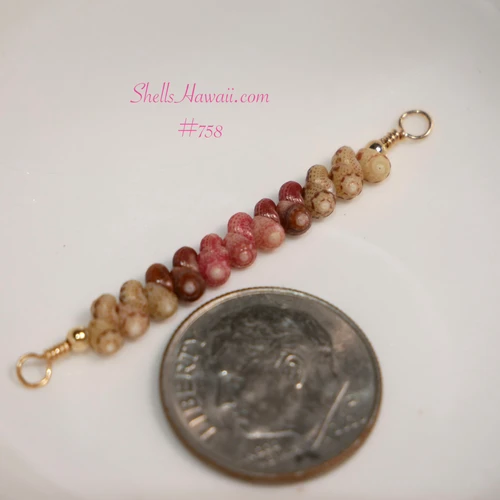 Close-up of tiny genuine Niʻihau Kahelelani shells in green, brown and pink flower colors for a minimalist shell necklace, shown beside a dime for size comparison.