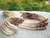 ninl_22123
Full display of museum-quality long Niʻihau triple-strand Kipona shell lei handcrafted with white Keʻokeʻo, yellow Lenalena, and brown-spotted Momi shells alongside colorful Kahelelani shell sections in pink flower, green, brown, and red burgundy tones with traditional granulated cowrie shell clasp.