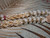 Close-up of the last section of Kipona style Niʻihau shell lei featuring white Momi shells, green Kahelelani shells, and yellow Momi shells arranged in a Crown Flower design, highlighting layered pattern, color balance, and fine handcrafted detail ニイハウシェル クラウンフラワー デザイン