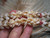 Close-up of the last section of Kipona style Niʻihau shell lei featuring white Momi shells, green Kahelelani shells, and yellow Momi shells arranged in a Crown Flower design, highlighting layered pattern, color balance, and fine handcrafted detail ニイハウシェル クラウンフラワー デザイン