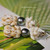 Close-up of pineapple motif showing concentrated yellow shells forming body with Laiki shell accents, topped by lustrous peacock Tahitian pearl; shells polished and color vibrant.
