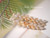 Authentic Niʻihau Mom i shells in yellow Lenalena and blue ʻUliʻuli varieties; strung into a Pikake style cluster reflecting ocean and sunshine.