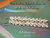 3½″ Pūpū O Niʻihau Pikake style earrings with Lenalena Kahakaha striped yellow tones, ʻEleʻele Waha black-lipped mouths, and off-white Momi shells forming a flowing floral cluster.
