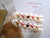 Luxury Niʻihau shell jewelry piece—Heliconia Flower Style #2533—white Momi body with pink flower and green Kahelelani accents; authentic craftsmanship and island charm.
