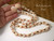 Rare Lenalena Momi shells from Niʻihau glow softly in this two-strand Kipona lei, accented by pink and burgundy Kahelelani shells from Kauaʻi. Authentic Hawaiian jewelry with cowrie clasp.