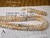 Niʻihau shell jewelry set created in Single Pikake style featuring a 40" lei and 3" earrings. Colors include white Keʻokeʻo, golden Lenalena, light blue ʻŪliʻuli ʻĀhiehie, and unique caramel Momi shells.