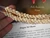Close-up of the last section of the Niʻihau shell lei held in hand, showing size comparison, color matching, workmanship, and luster of the shells, highlighting this one-of-a-kind design before finishing with the clasp.