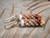 1 1/4" Niʻihau Kahelelani shell earrings in yellow kamoa, red burgundy, green, and natural keʻokeʻo colors, 4-strand Poepoe style.
